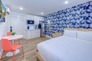 ガルベストンにあるTropical Sunset Studio Apartmentのベッドとテーブルとキッチンのある寝室