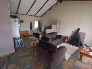 a living room with two couches and a fireplace at Votadini Country Cottages in Magaliesburg