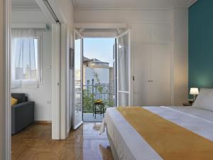 a bedroom with a large bed and a balcony at Acropolis View top floor apartment in Athens