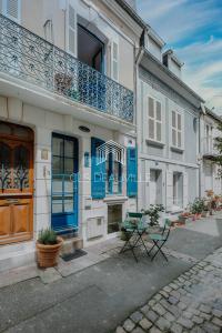 un edificio con puertas azules y una mesa delante de él en Maison de Pêcheur La Coquette CLS Deauville en Trouville-sur-Mer