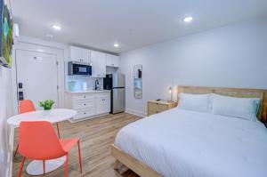 Caribbean Sea Studio Apartment في جالفيستون: غرفة نوم بسرير وطاولة وكراسي