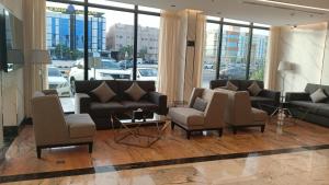 فايف بالم الفندقية في الرياض: غرفة معيشة مع كنب وكراسي في مبنى