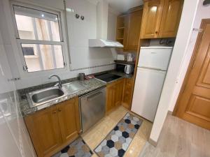 eine kleine Küche mit Spüle und Kühlschrank in der Unterkunft Homely Apartments Las Salinas in Torrevieja