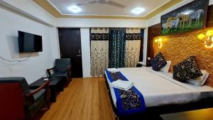 une chambre d'hôtel avec un lit, une chaise et une télévision dans l'établissement The Indian Kargil, à Kargil