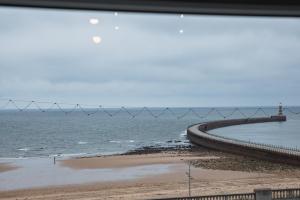 Blick auf einen Strand mit einem Pier und das Meer in der Unterkunft 5 Roker Terrace - Seaview apartments in Sunderland