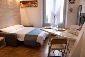 Cette petite chambre comprend un lit, une table et une cuisine. dans l'établissement Casa Bel, Bologna By Short Holidays, à Bologne
