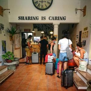 a group of people standing in a waiting room with luggage at Urban Oasis Hostel in Lecce