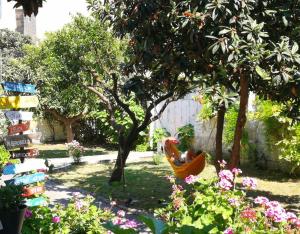 una hamaca en un jardín con árboles y flores en Urban Oasis Hostel en Lecce
