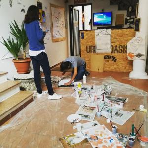 two women working on the floor in a room at Urban Oasis Hostel in Lecce