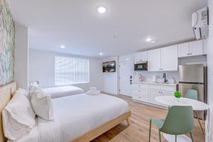 a white bedroom with a bed and a kitchen at Beverly Hills Studio Apartment 2 Queen Beds in Galveston