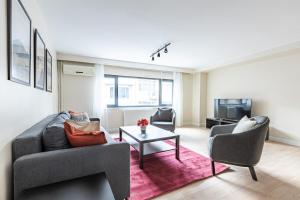 een woonkamer met een bank en stoelen en een tv bij Brand New Modern Prime 2bd1bath Cozy Home! #244 in Istanbul