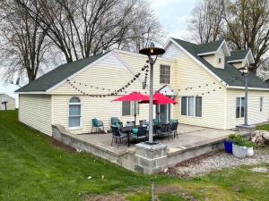 Casa con patio con mesa y sillas en Lake Cottage with Garage, en Malone