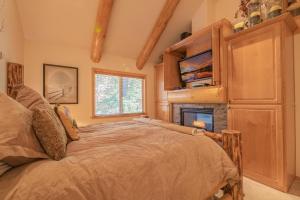 a bedroom with a bed and a fireplace at Bearfoot Bungalow - Premium and spacious home close to the National Forest and The Village! in Big Bear Lake