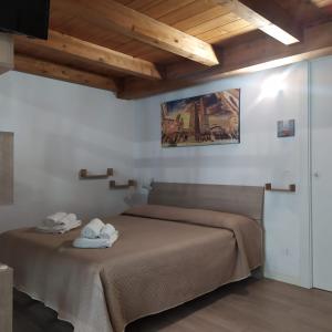 1 dormitorio con 1 cama con toallas en BHH bolognaholidayhome Appartamento Signorini - Casa indipendente Bologna Centro - Giardino e Posto Auto -, en Bolonia