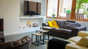 a living room with a couch and a tv at Casa de Trinidad Segovia in Segovia