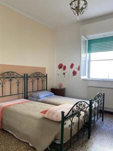 two beds in a bedroom with a window at Appartamento luminoso a due passi da Piacenza in Caorso