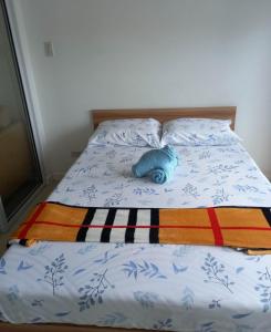- un lit avec un oreiller bleu dans l'établissement SM Bicutan Rooms, à Manille