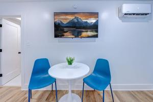 a table and chairs in a room with a painting on the wall at Roaring Tigers Studio Apartment in Galveston