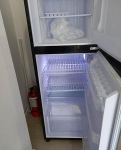 an empty refrigerator with its door open with its door at SM Bicutan Rooms in Manila