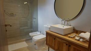 uma casa de banho com um WC, um lavatório e um espelho. em 718 Rufino Petit Hotel em Mendoza