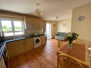 a kitchen and dining room with a table and a kitchen and a couch at 2a Ardaravan Square in Buncrana