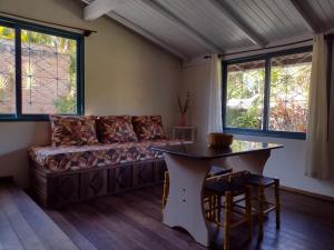una sala de estar con un sofá y una mesa en Casas Porto Belo, recanto em meio a natureza e próximo a praia, en Porto Belo