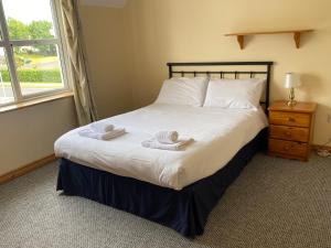 a bedroom with a bed with two towels on it at 2a Ardaravan Square in Buncrana