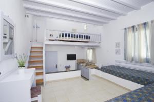 ein großes Wohnzimmer mit einer Treppe und einem TV in der Unterkunft Villa Margarita in Mykonos Stadt