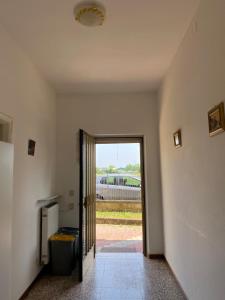 um corredor com uma porta para um quarto com uma janela em Appartamento luminoso a due passi da Piacenza em Caorso