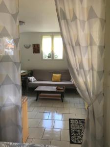 ein Wohnzimmer mit einem Sofa und einem Fenster in der Unterkunft Studio proche mer & climatisé les Anses d'Arlet in Les Anses-dʼArlets