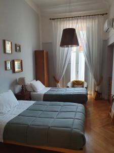 une chambre d'hôtel avec deux lits et un canapé dans l'établissement La Dimora dei Reali, à Naples
