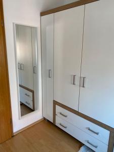 a bedroom with a large white cabinet and a mirror at Privatquartier im Ortskern von Westerstede in Westerstede