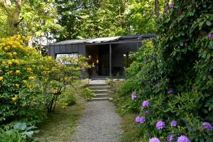 a black house in the middle of a garden with flowers at Domki Karpatia BB in Bielsko-Biala