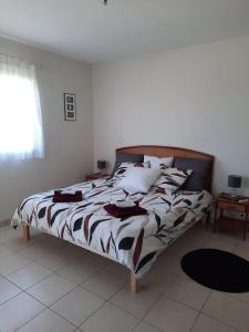 een slaapkamer met een bed met een bruin en wit dekbed bij Chez Papi à Lascaux in Montignac
