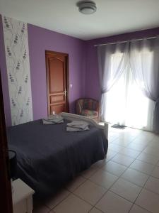 een slaapkamer met een bed, een raam en een stoel bij Chez Papi à Lascaux in Montignac