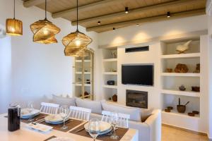 a dining room with a table and a television at Manolis House in Sitia