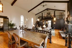 une salle à manger avec une grande table et des chaises en bois dans l'établissement The Prince Edward County Church, à Belleville