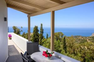 a balcony with a table and chairs and the ocean at Manolis House in Sitia