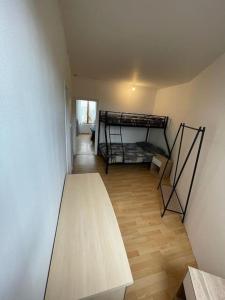 Zimmer mit einem Holztisch und einem Etagenbett in der Unterkunft agréable maison 7 personnes proche centre ville de Nogent in Nogent-le-Rotrou