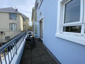 a balcony with a table and chairs next to a building at 2a Ardaravan Square in Buncrana