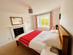 a bedroom with a large bed and a fireplace at Apple Tree Cottage in Marske