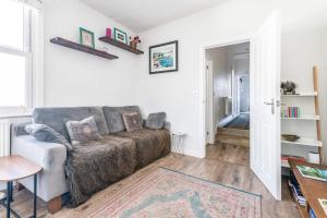 a living room with a couch and a table at Chic and Cheerful Flat in Willesden Green in London