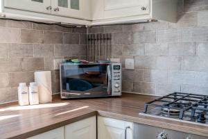 a microwave oven sitting on top of a kitchen counter at Chic and Cheerful Flat in Willesden Green in London