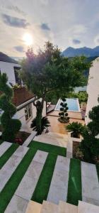un jardín con césped y un árbol y un edificio en Koman Paradise by Romina en Shkodër