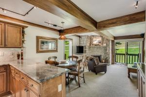 a kitchen with a table and a living room at Interlude Condominiums 2-Bedroom Unit 205 in Snowmass Village