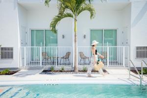 a woman walking next to a swimming pool at Mint House St. Petersburg - Downtown in St Petersburg