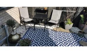 a patio with two chairs and a table on a rug at The Big Slepe in St. Ives