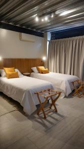 a room with two beds and a window at 718 Rufino Petit Hotel in Mendoza