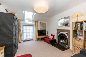 a living room with a fireplace and a tv at Fern Hse Grassington; central yet quiet & parking in Grassington