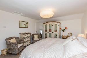 1 dormitorio con 1 cama blanca grande y 1 silla en Fern Hse Grassington; central yet quiet & parking, en Grassington